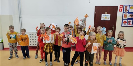 Powiększ grafikę: Grupa dzieci z zerówki ubrana na pomarańczowo z rysunkami  pomarańczowego słonika.
