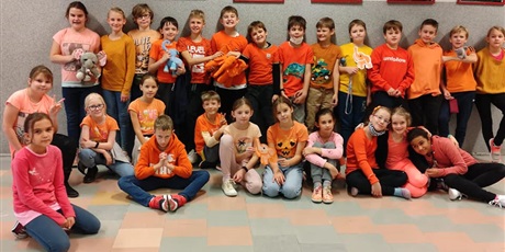 Powiększ grafikę: Grupa dzieci z klas 4 ubrana na pomarańczowo.